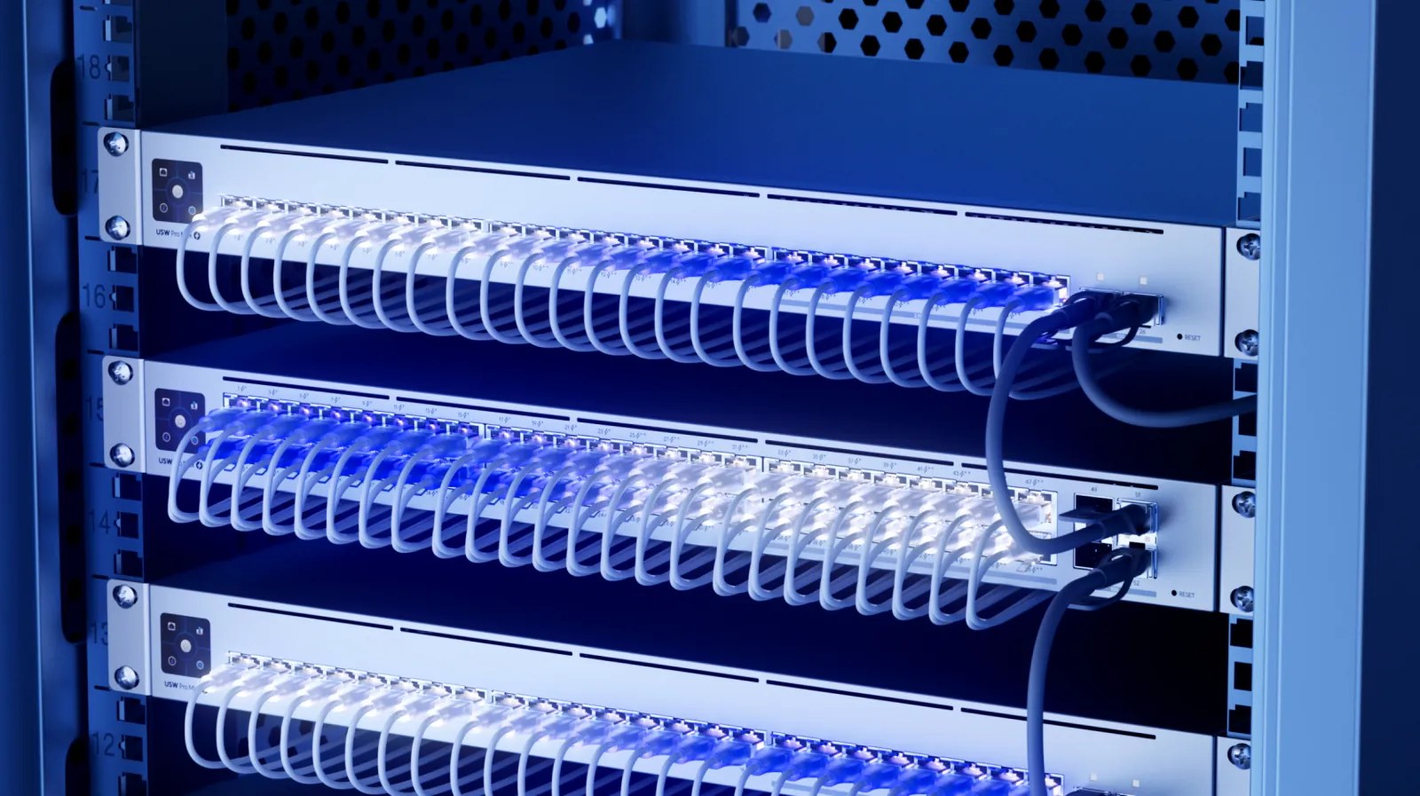 Baies de serveurs avec switches réseau et câbles bleus illuminés, gros plan
