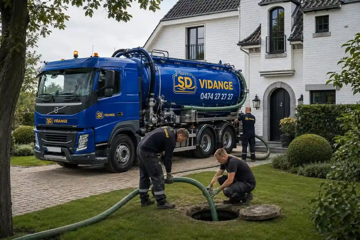 Deux techniciens SD Vidange interviennent sur une fosse septique devant une maison